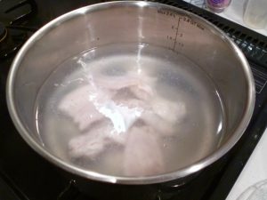 沸騰したお湯に鶏肉を入れる